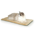 Cat lying on a beige heating pad with a white background